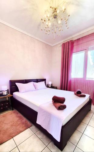 a bedroom with a large bed with a chandelier at Apartman Malvina in Flogita