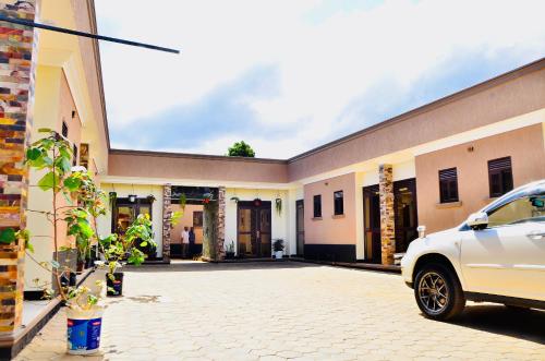 a white car parked in front of a building at Townside Suites in Kyebando