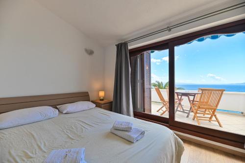 a bedroom with a bed and a view of the ocean at LUXURY VILLA CIOVO Sleeps 17, Infinity Pool, Seafront in Trogir