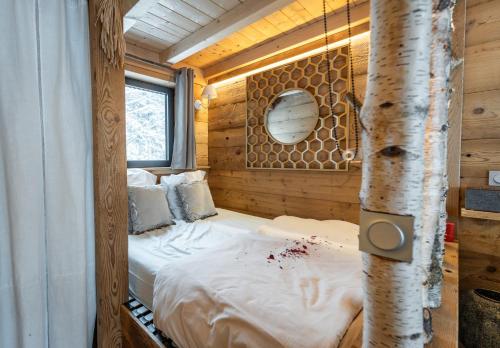a bedroom with a bed in a tree house at lodge 1 - les jolis chalets in Barbey-Séroux