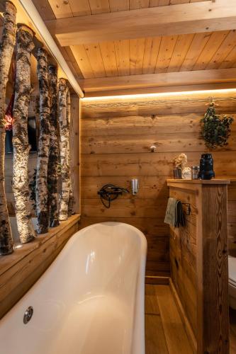 a bathroom with a tub in a log cabin at lodge 1 - les jolis chalets in Barbey-Séroux