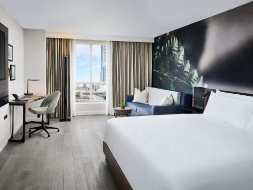 ein Hotelzimmer mit einem großen Bett und einem Schreibtisch in der Unterkunft The Novotel Toronto Centre in Toronto