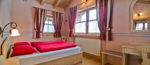 a bedroom with a bed with red pillows at Chalet Betty in Livigno