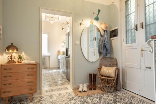 a hallway with a mirror and a chair and a dresser at Lake House Lesa - Lakeside Villa Lago Maggiore in Lesa