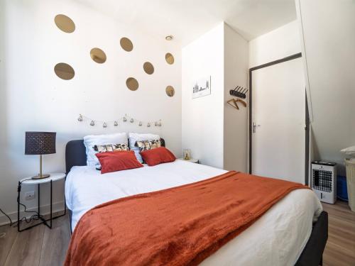 a bedroom with a large white bed with red pillows at Les Fontaines in Bernay