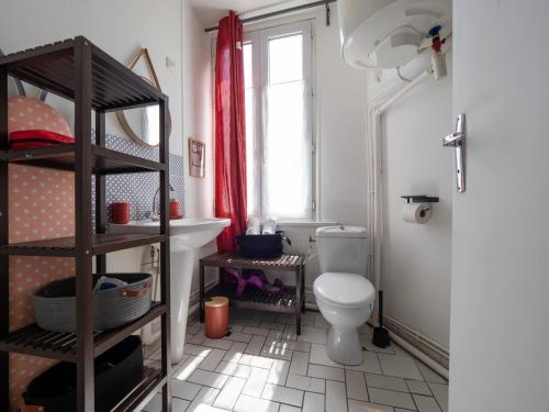 a bathroom with a toilet and a sink and a window at Les Fontaines in Bernay