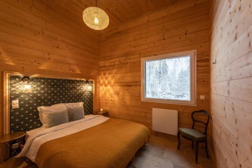 a bedroom with a bed in a wooden cabin at chalet 1 - les jolis chalets in Barbey-Séroux