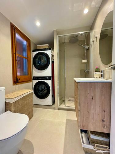 a bathroom with a toilet and a washing machine at Casa en Sant Antoni de Calonge in Calonge