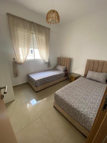a bedroom with two beds and a chandelier at Super appartement in Hauara