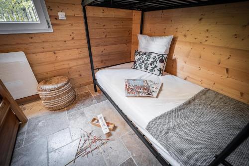 a small room with a bed in a wooden cabin at chalets 4 - les jolis chalets in Barbey-Séroux