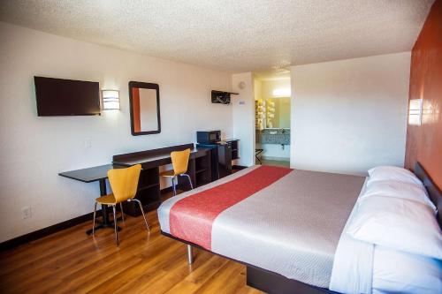 コーシカーナにあるMotel 6-Corsicana, TXのベッドとデスクが備わるホテルルームです。