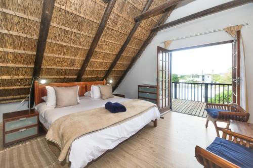 a bedroom with two beds and a balcony at The Barn Main House in Arniston