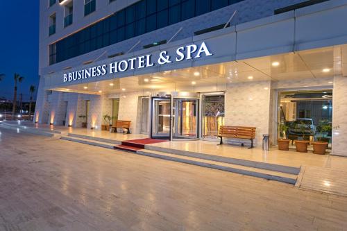 a hotel and spa building with benches in front of it at B Business Hotel & Spa in Antalya