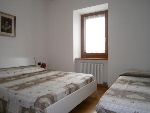 モルヴェーノにあるAppartamento Biancospinoのベッドルーム1室(ベッド2台、窓付)