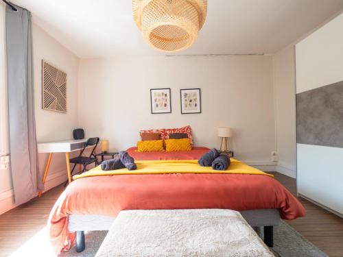 a bedroom with a large bed with red and yellow sheets at La Chaussee in Bernay