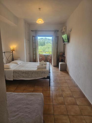 a bedroom with two beds and a large window at Arianna Studio Ground Floor 2 in Paleokastritsa