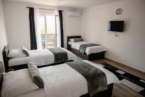 a room with three beds and a television in it at Pansioni Centar in Mostar