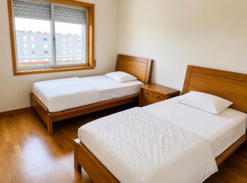 a bedroom with two beds and a window at PORTO AGUDA BEACH ***** in Arcozelo