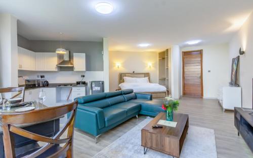 a living room with a blue couch and a bed at Kika Des Hotel Suites - Serviced Apartments, Westland, Nairobi in Nairobi