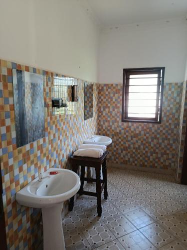 a bathroom with two sinks and a mirror at Peaceful Diani apartment in Diani Beach