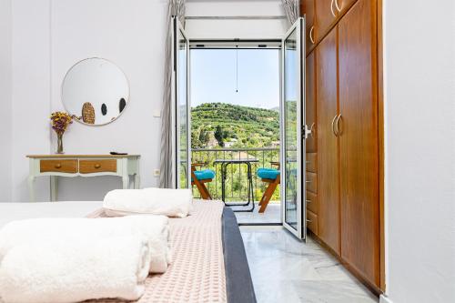 a bedroom with a bed and a door with a balcony at Achilleas Deluxe House-Jacuzzi - BBQ in Kotsianá
