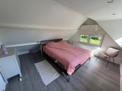 a bedroom with a bed with a red blanket at Vakantiewoning Sjun Limburg in Simpelveld