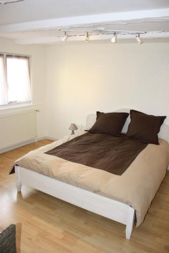 une chambre avec un grand lit dans une pièce blanche dans l'établissement Gites des Dix Vins, à Dangolsheim