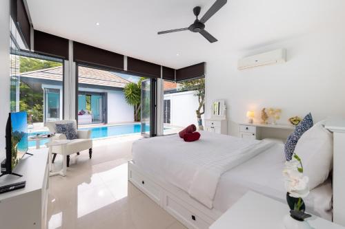 a bedroom with a large bed and a living room at 4BR Luxury Pool Retreat - Villa Azura Nai Harn in Nai Harn Beach