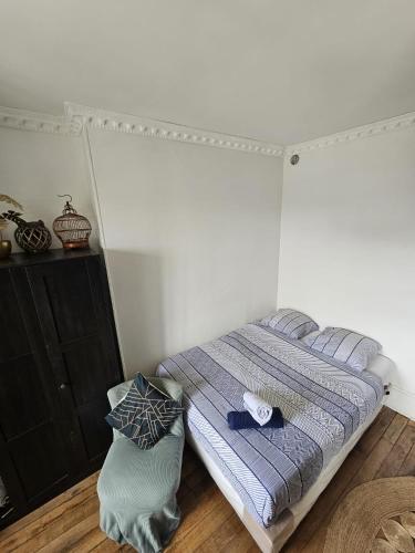 a bedroom with a bed with a blue comforter at Bel Apt châteaux de Vincennes in Vincennes