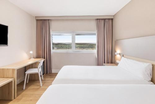 a hotel room with a bed and a desk at B&B HOTEL Logroño Las Cañas in Viana