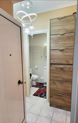 a bathroom with a toilet and a large wooden door at Apartman Malvina in Flogita