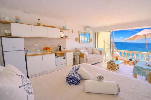 a kitchen and living room with a view of the ocean at Vue mer & terrasse Studio calme parking St Raphaël in Saint-Raphaël