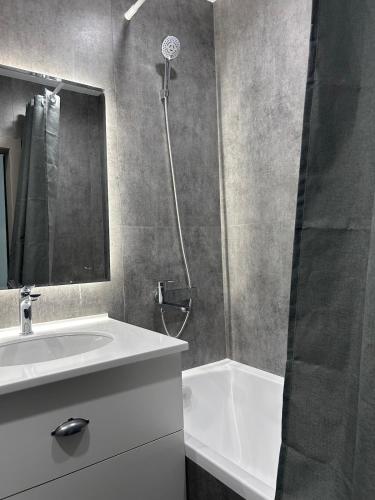 a bathroom with a sink and a shower at Modern Apt in Shymkent