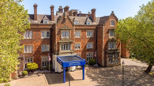 a large brick building with a blue sign in front of it at North Stafford Hotel in Stoke on Trent