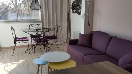 カンヌにあるLes Sablonsの紫色のソファとテーブル付きのリビングルーム