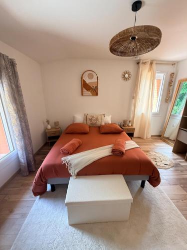 a bedroom with a large bed with a red blanket at Le 25 Bis Spa&Sauna aux portes de Montauban in Lamothe-Capdeville