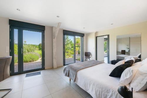 a bedroom with a large bed and sliding glass doors at Gite Du Bois in Ponts