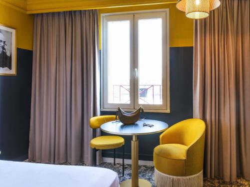 a hotel room with a bed and a table and chairs at Mercure Honfleur in Honfleur