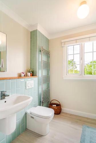 a bathroom with a white toilet and a sink at Dalforth Thaxted Barn Collection in London Stansted Airport