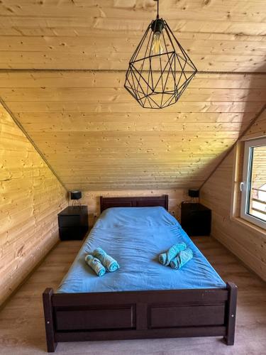 a bed in a room with a wooden ceiling at Chatki Bies-Czadowe-Czad in Berezka