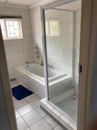 a white bathroom with a tub and a shower at Tortilla no 3 in Bloemfontein