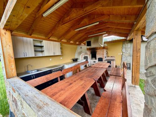a large kitchen with wooden tables and a counter at Wellness Chalet Tatry in Vysoké Tatry