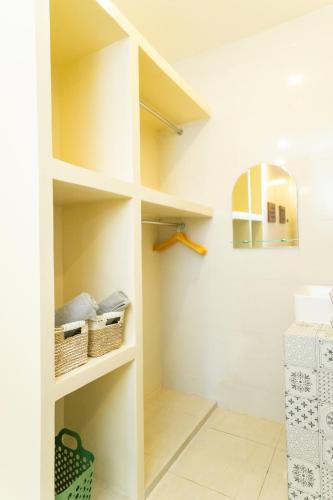 a bathroom with white shelves and a mirror at Casa Seraya Dalung in Dalung