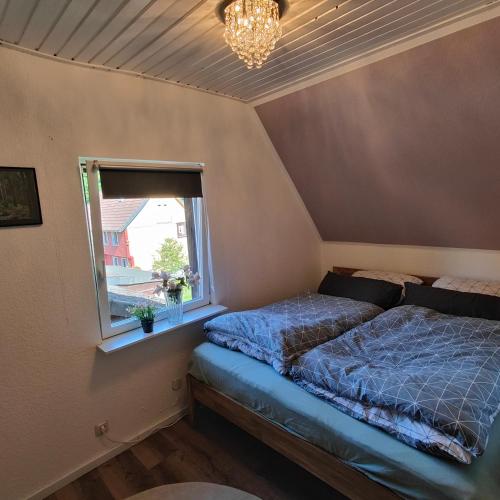 a bedroom with a bed and a window at Altenauer Kaffee-Chalet in Altenau