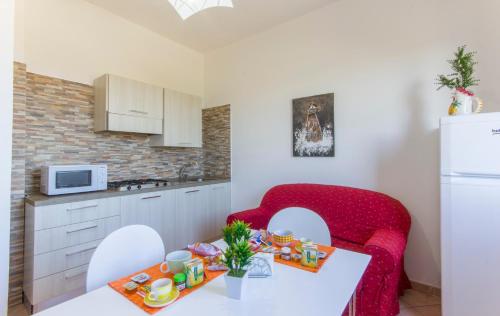 a kitchen with a table and a red couch in a room at Appartamenti Elios in Birgi Vecchi