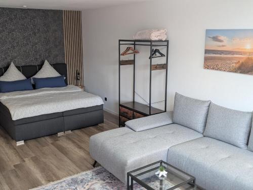 a living room with a bed and a couch at Gemütliche Ferienwohnung im Lotsenviertel in Cuxhaven