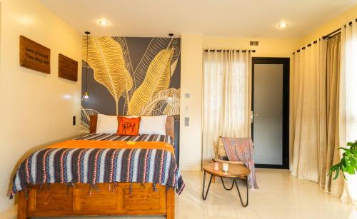 a bedroom with a bed and a chair at Casa Seraya Dalung in Dalung
