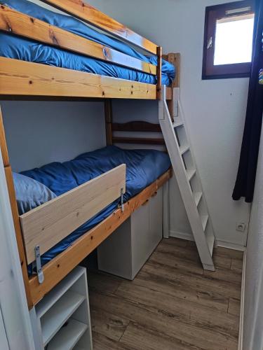 a bunk bed room with two bunk beds and a ladder at studio cabine vue sur mer in Sète
