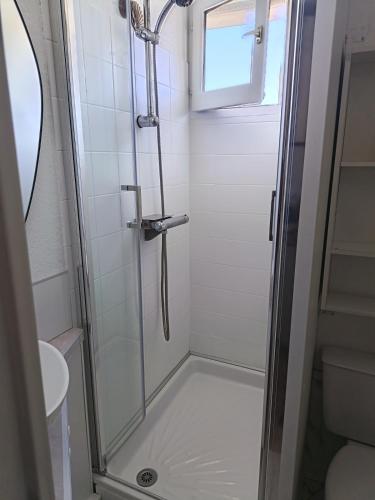a shower with a glass door in a bathroom at studio cabine vue sur mer in Sète