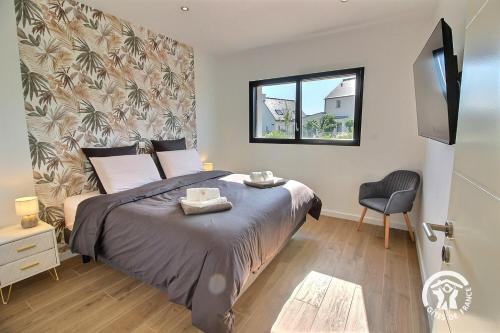 a bedroom with a bed and a window and a chair at Enez bihan in Plougrescant